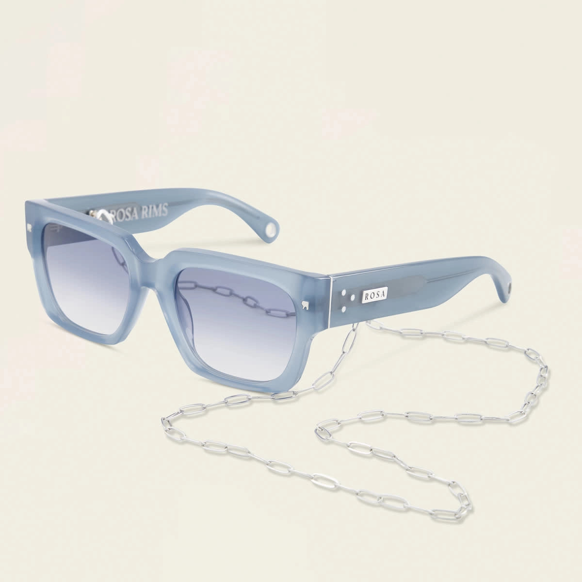 Blue sunglasses with a chain on a light beige background