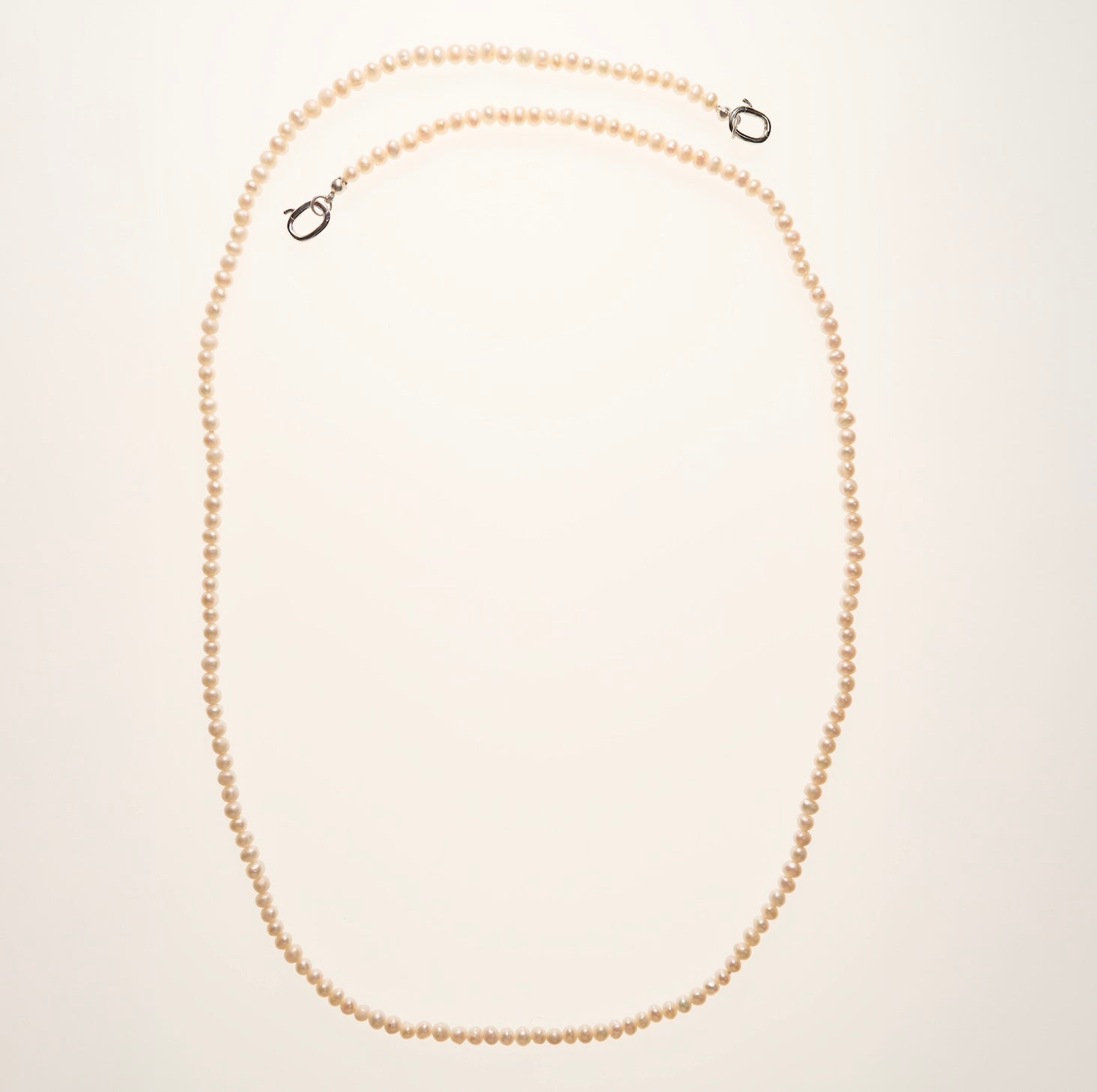 Pearl necklace on a light beige background
